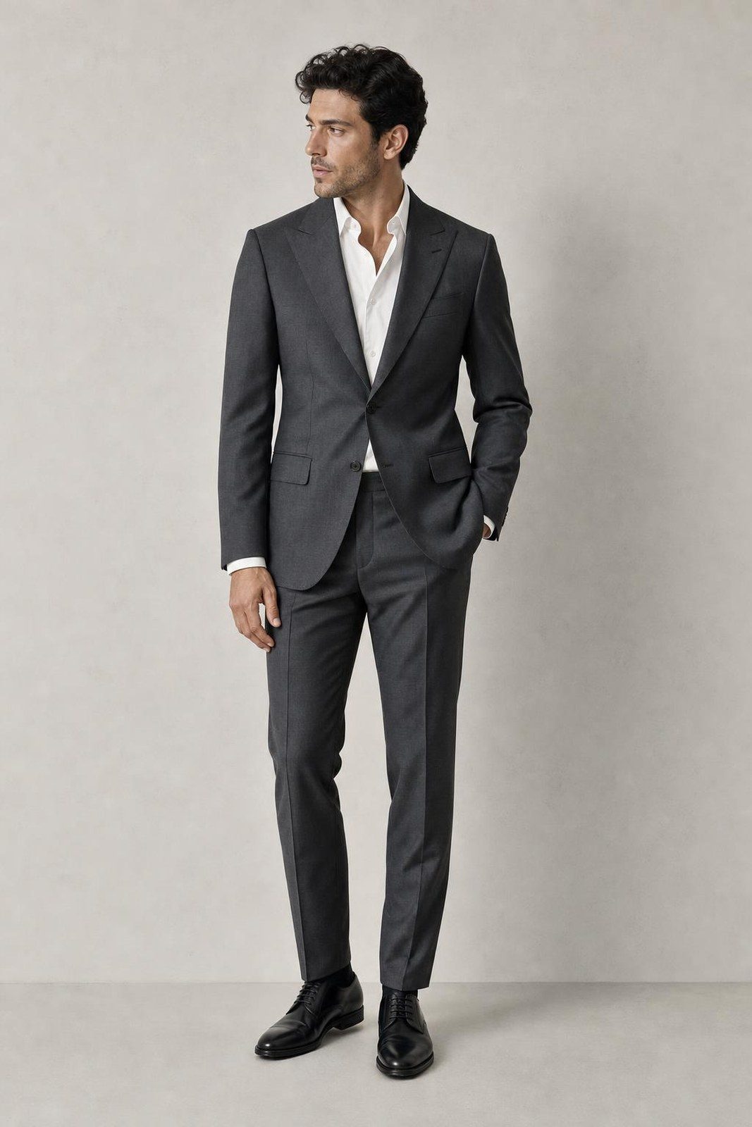 A model wearing a charcoal two-piece suit with a white shirt